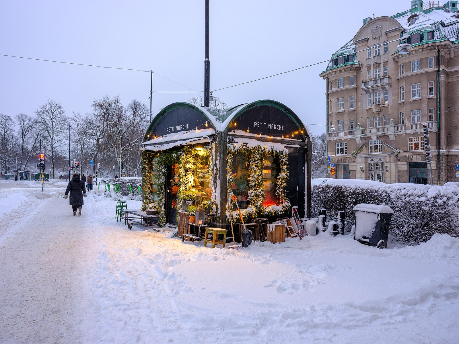 A flower kiosk glowing with light on a snowy winter street