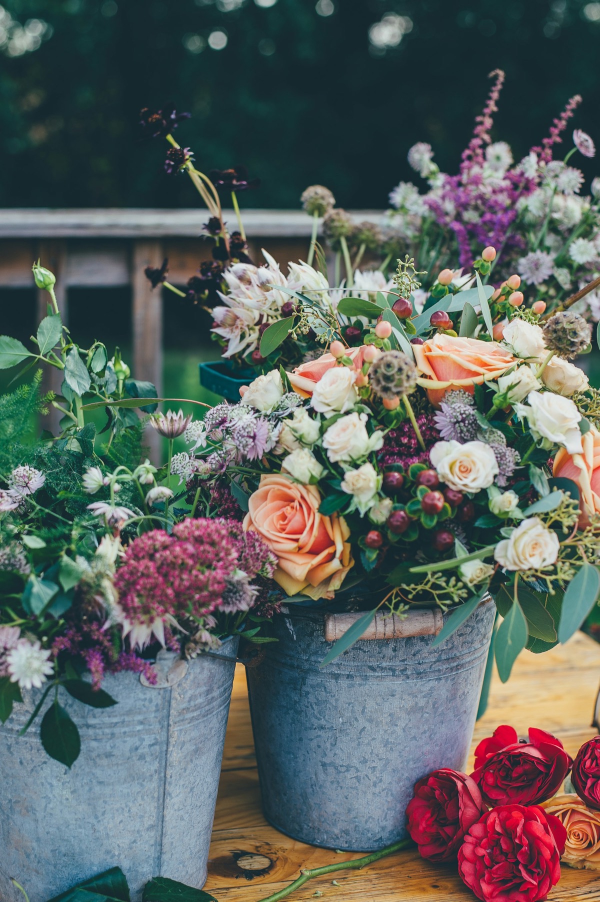 Buckets of mixed flowers and a bouquet on a market stall