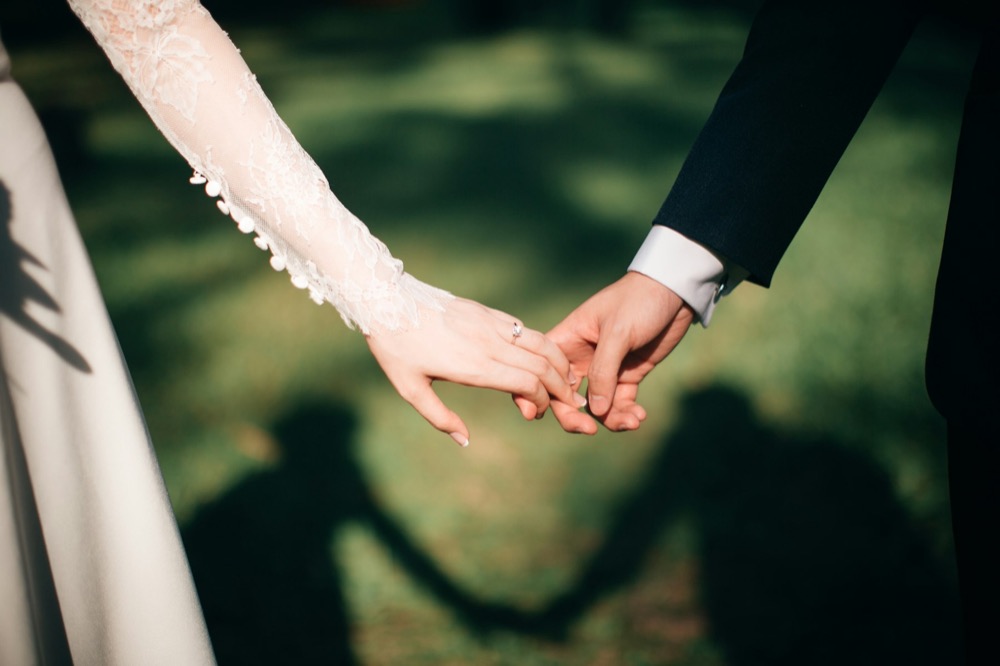 A couple holding hands on a lawn